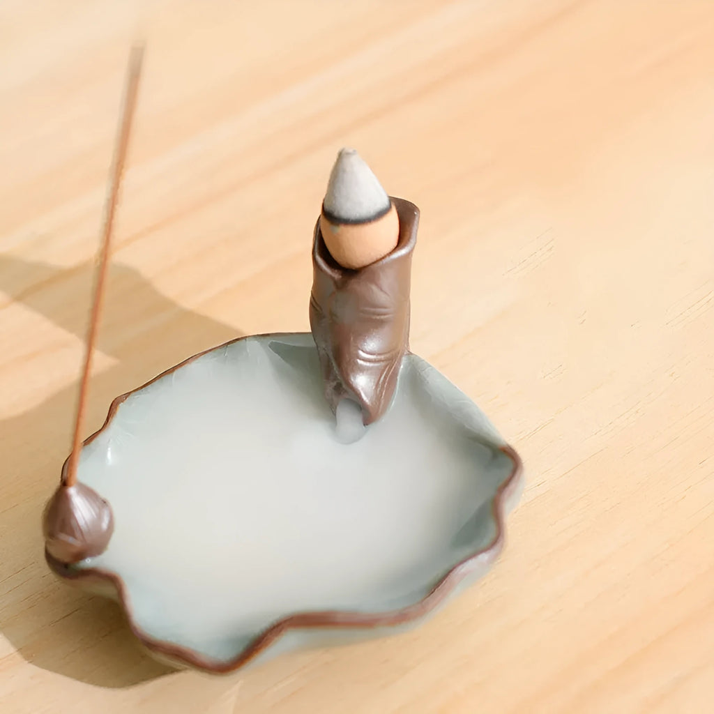 Ceramic reverse flow incense burner in purple clay with crystal glaze featuring lotus or plum blossom design