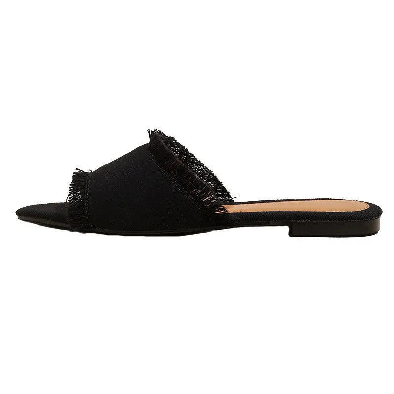 Women's denim flat slippers with leather lining and a tassel detail in various solid colours.
