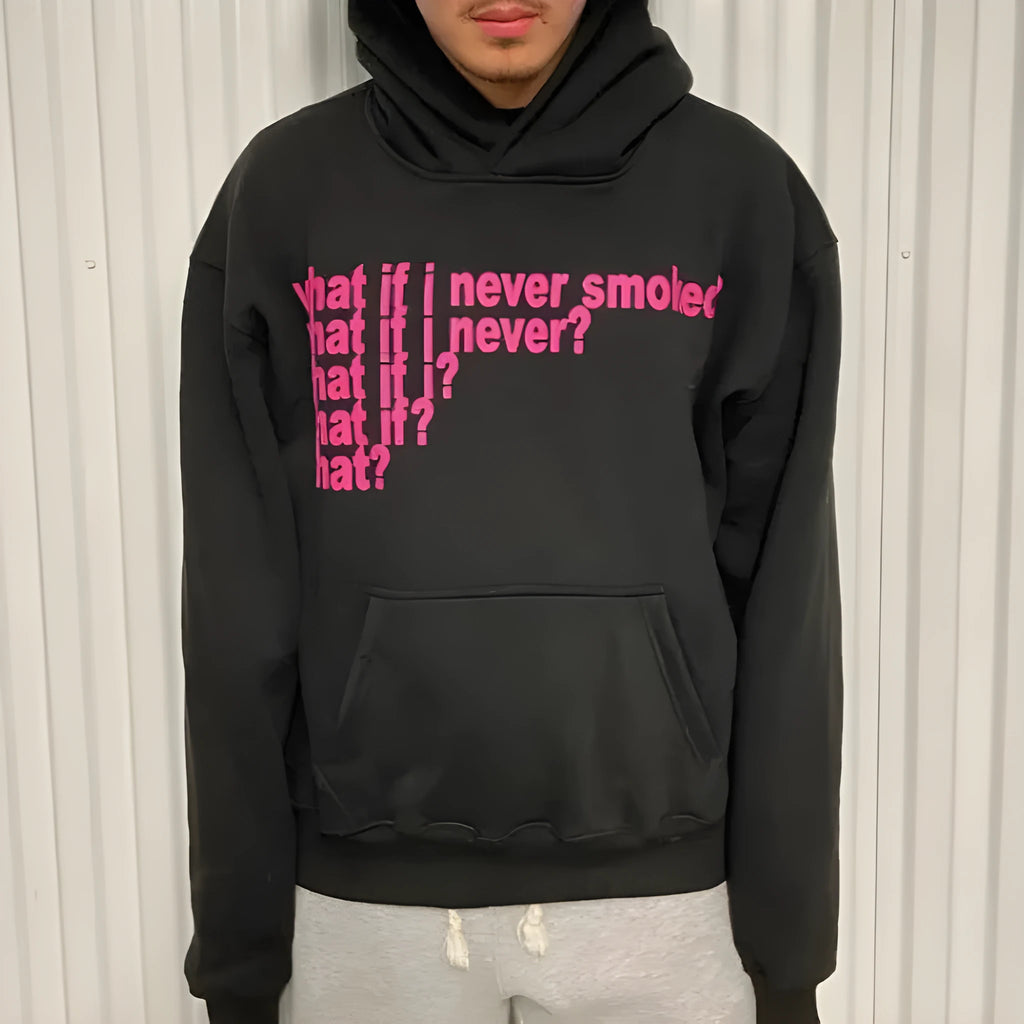Man wearing a black heavyweight hooded sweater with a large white letter print design on the front.