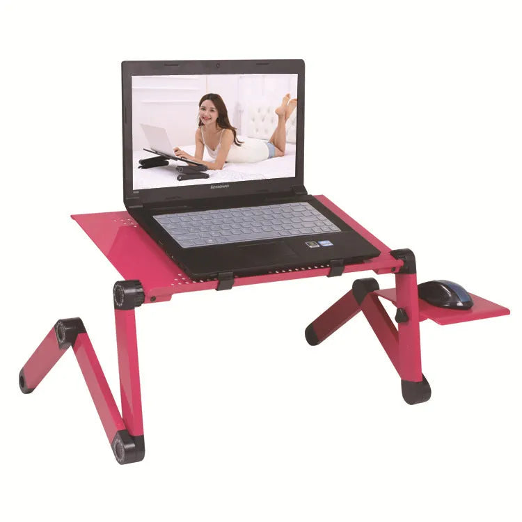 Black metal folding computer desk with cooling fan, extended on a bed.