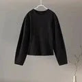 Women's black polar fleece long sleeve pleated top and wide leg trousers co-ord set on a hanger.