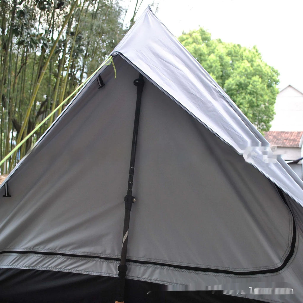Brown A-line cabin tent pitched with hiking poles as structural support showing spacious interior for 2-3 people