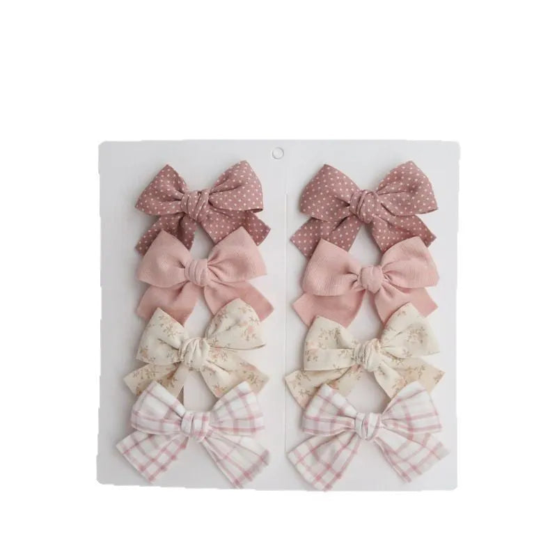 Children's fabric bow hairclips set showing dovetail design in multiple colour options