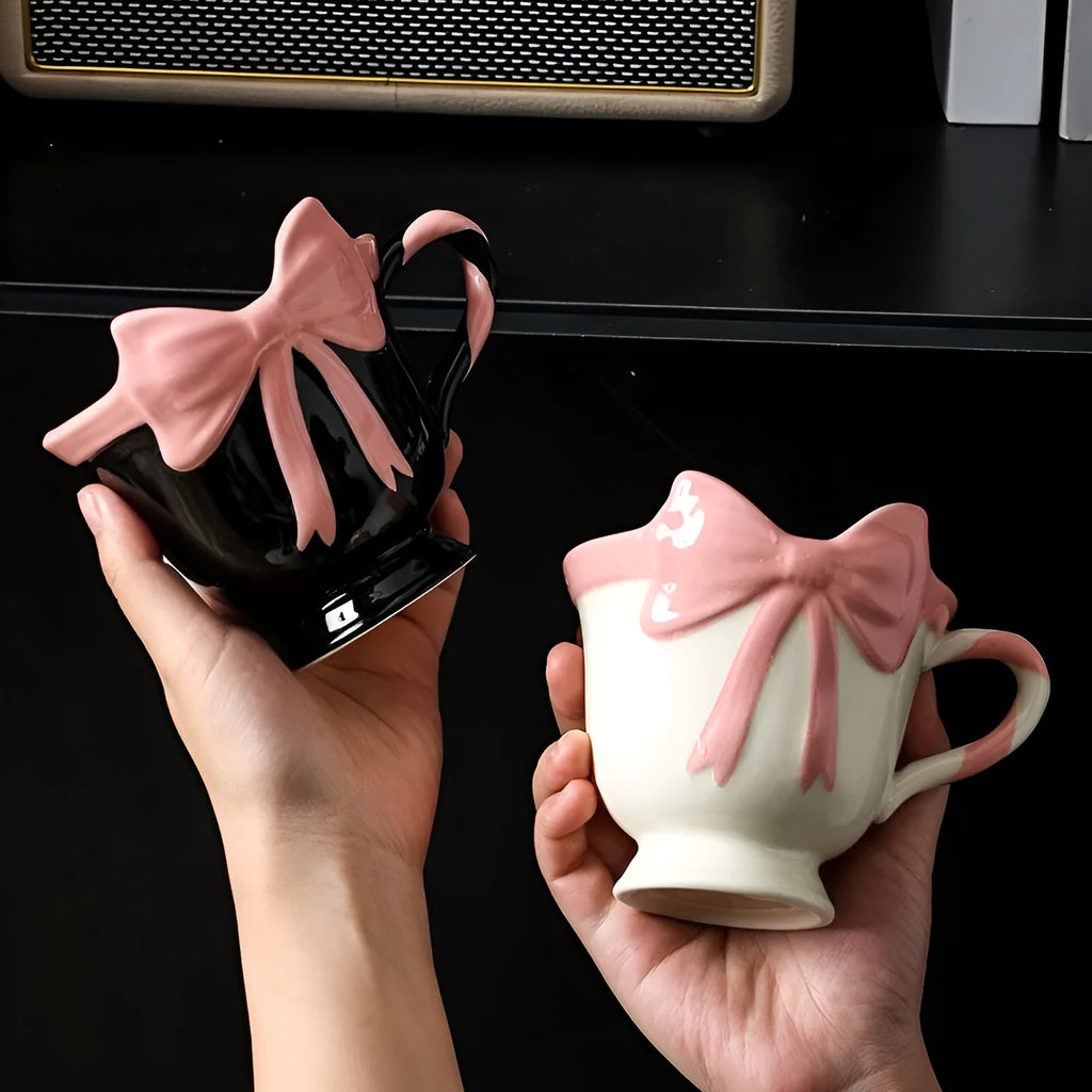 Ceramic mug with a heart and bow design in black pink and white powder colour options.