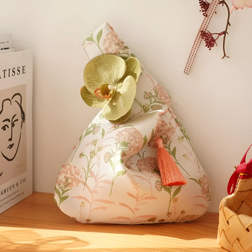 Chinese style gold silk jacquard hand-held cloth gift bag with flower accent in champagne colour on white background