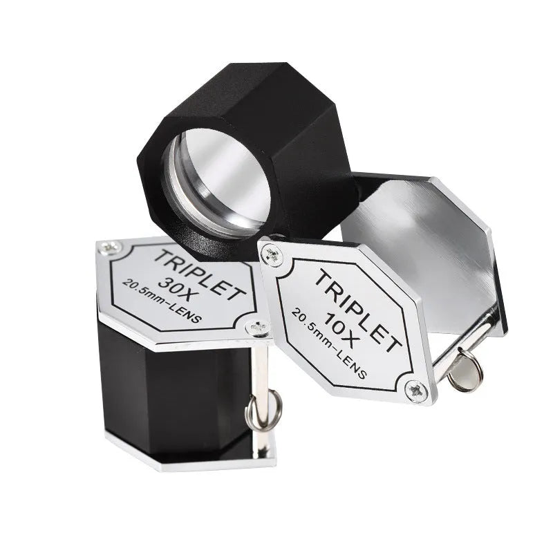 Handheld metal magnifying glass with optical lens for jewellery and stamp identification.