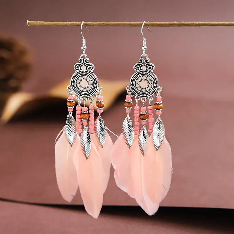 A pair of bohemian-style round drop earrings with a feather leaf pattern, shown in one of thirteen available colours.