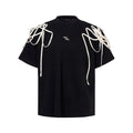 Black loose fit T-shirt with padded shoulders and decorative rivet ribbon detail on a short sleeve.