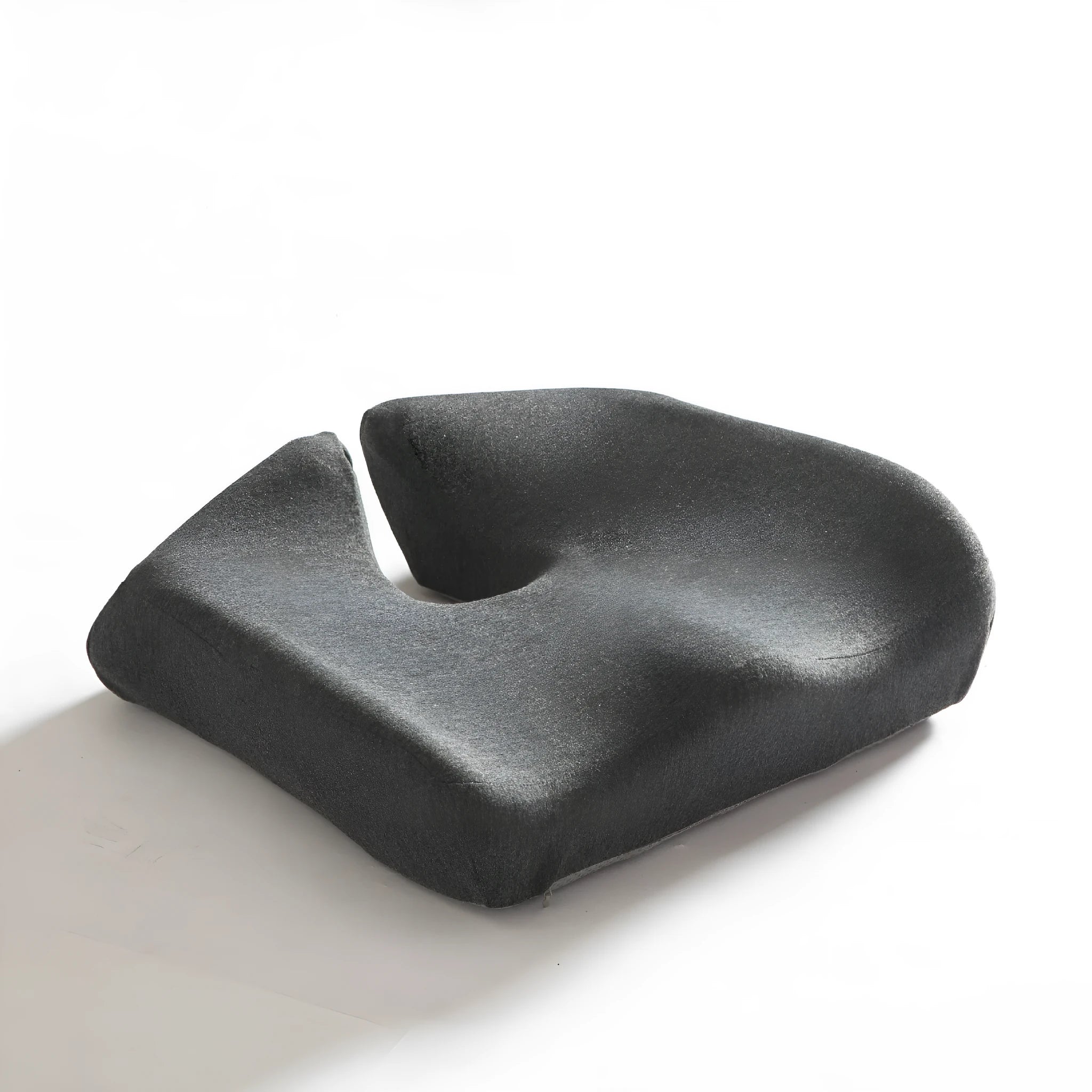 Dark grey memory foam office chair cushion with contoured shape for lower back support on a desk chair.