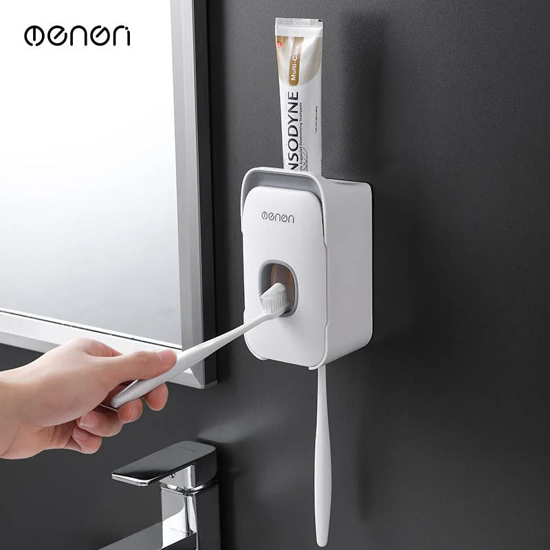 Automatic wall-mounted toothpaste dispenser in blue, grey, and pink colours with USB charging cable.