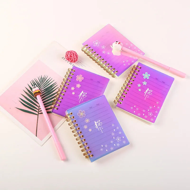 Set of four A7 spiral notebooks with different coloured PP plastic covers, showing spiral binding and open page.