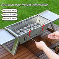 Small foldable portable charcoal grill for outdoor use.