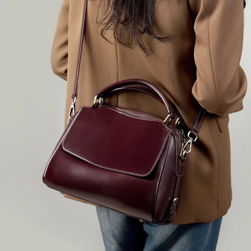 Women's soft cowhide leather crossbody tote bag in apricot colour, showing internal zip pockets and double shoulder strap.
