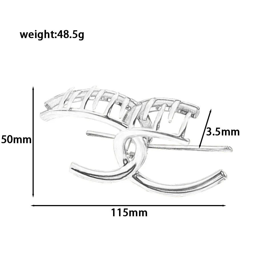 Assortment of silver metal hair claw barrettes with various designs including bows, pearls, and geometric shapes.