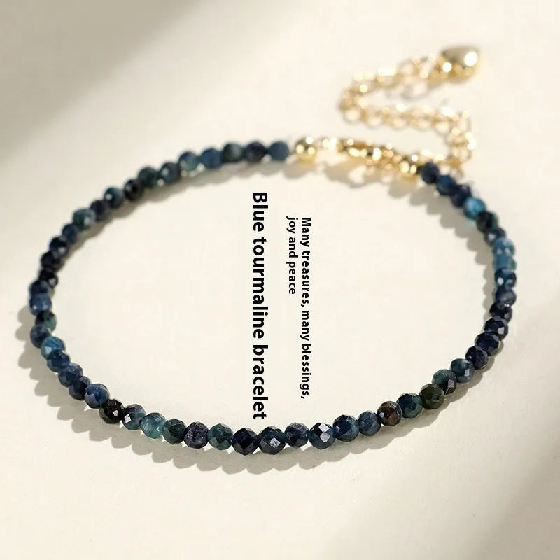 Close-up of a women's blue tourmaline gemstone beaded bracelet with 3mm beads and spacer design.