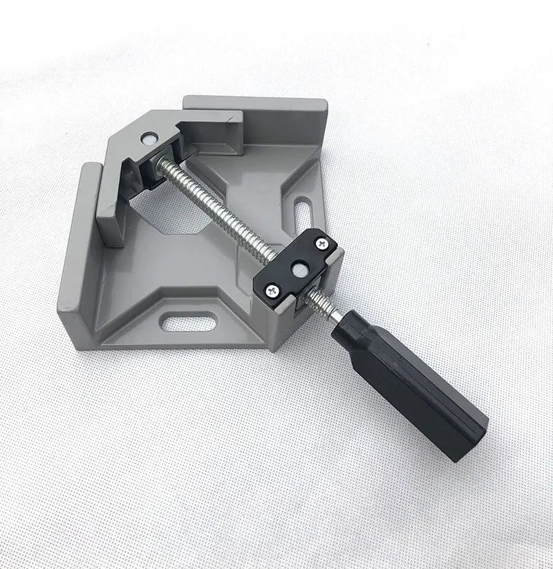 Black aluminium alloy 90 degree right angle clip with 70mm opening on a wooden workbench.