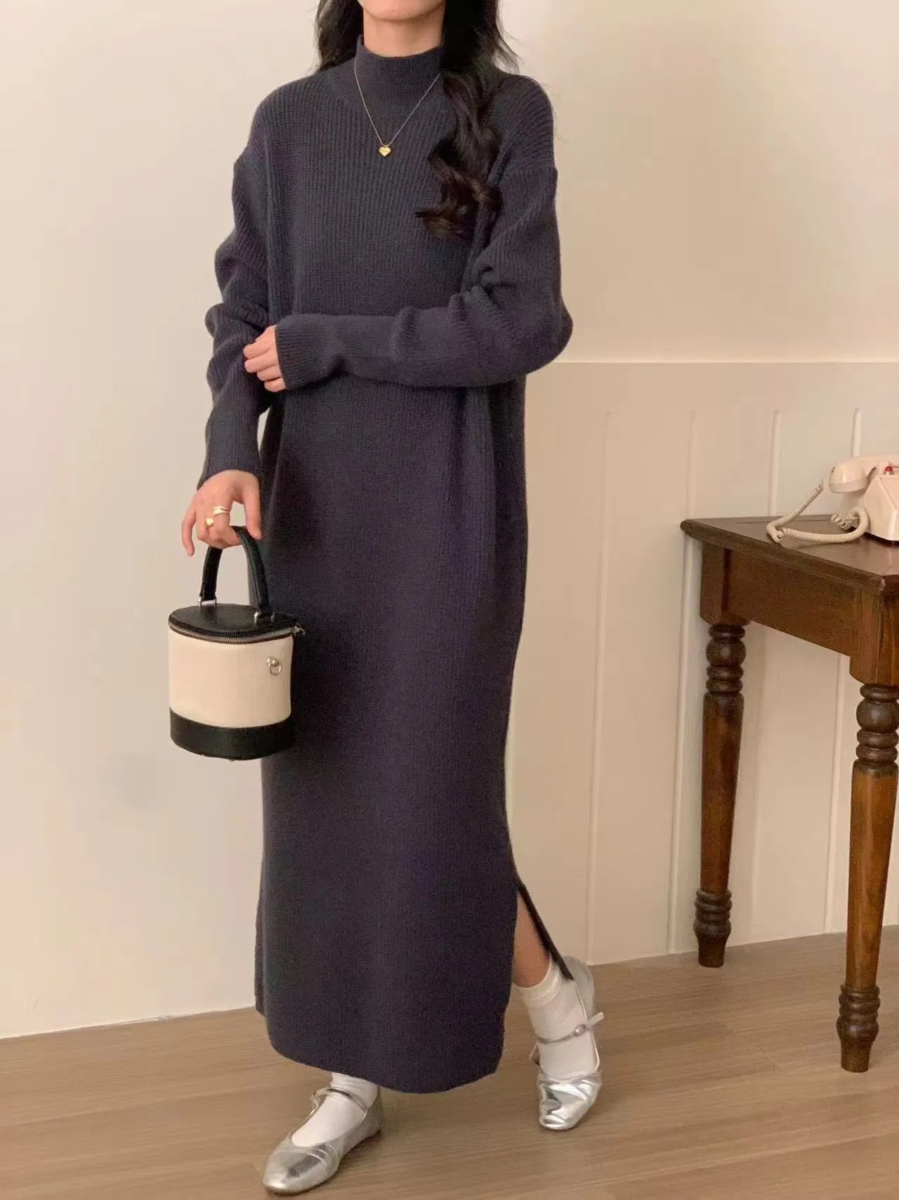 Woman wearing a beige half-turtleneck, high-waisted, knee-length acrylic knit dress.