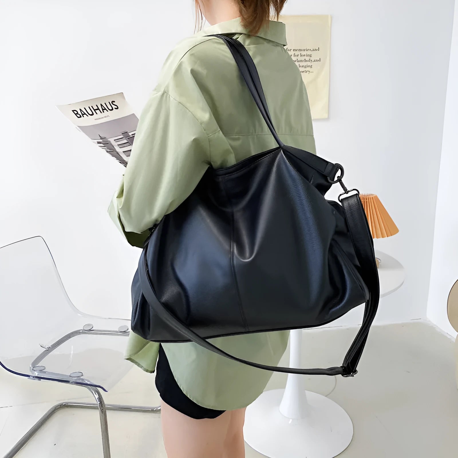 Large soft PU leather messenger bag with adjustable strap in black, shown open with internal pockets.