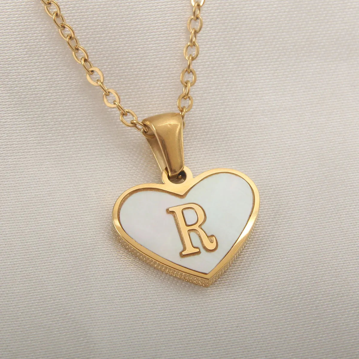 Gold plated heart-shaped white shell pendant personalised initial necklace on a stainless steel chain.