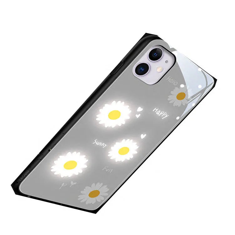 White daisy design voice-activated luminous TPU case for Apple iPhone on a table.
