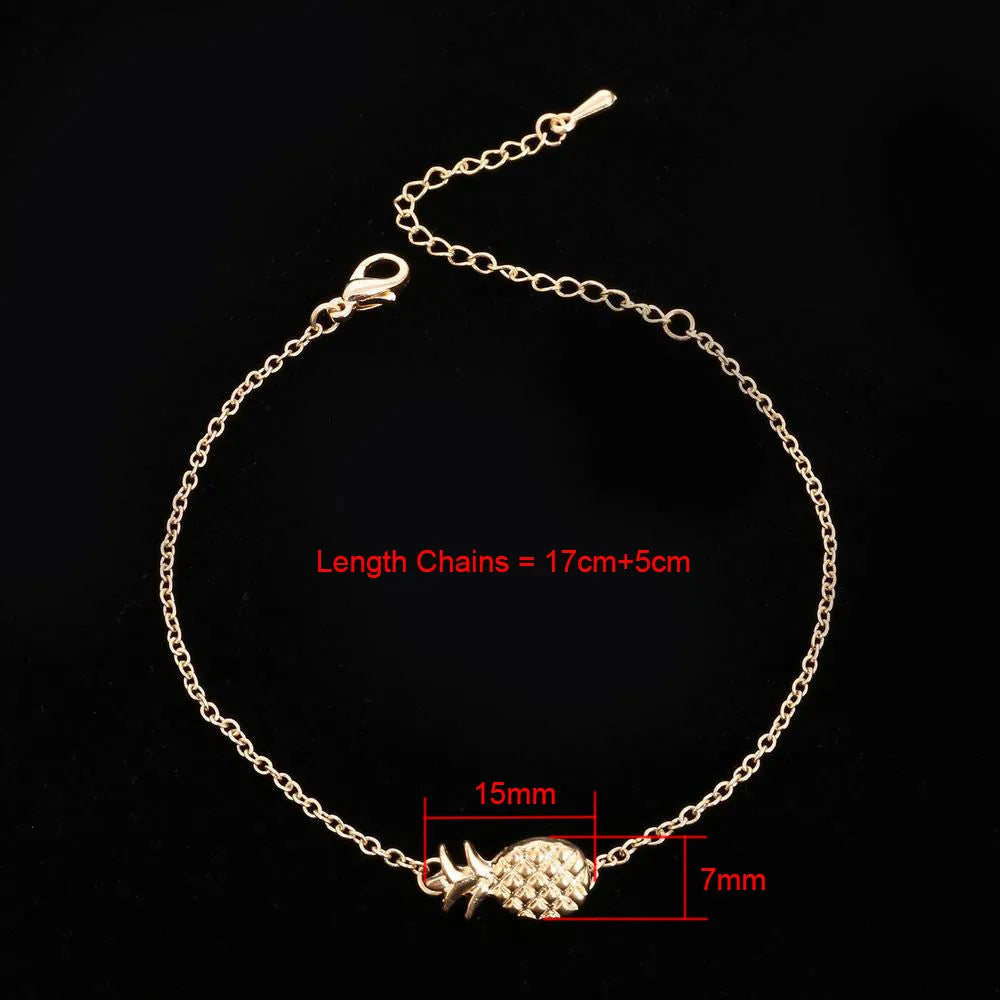 Close-up of a gold-coloured alloy bracelet with a pineapple charm on a simple chain.