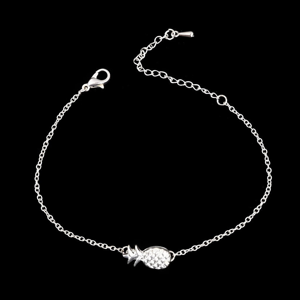 Close-up of a gold-coloured alloy bracelet with a pineapple charm on a simple chain.