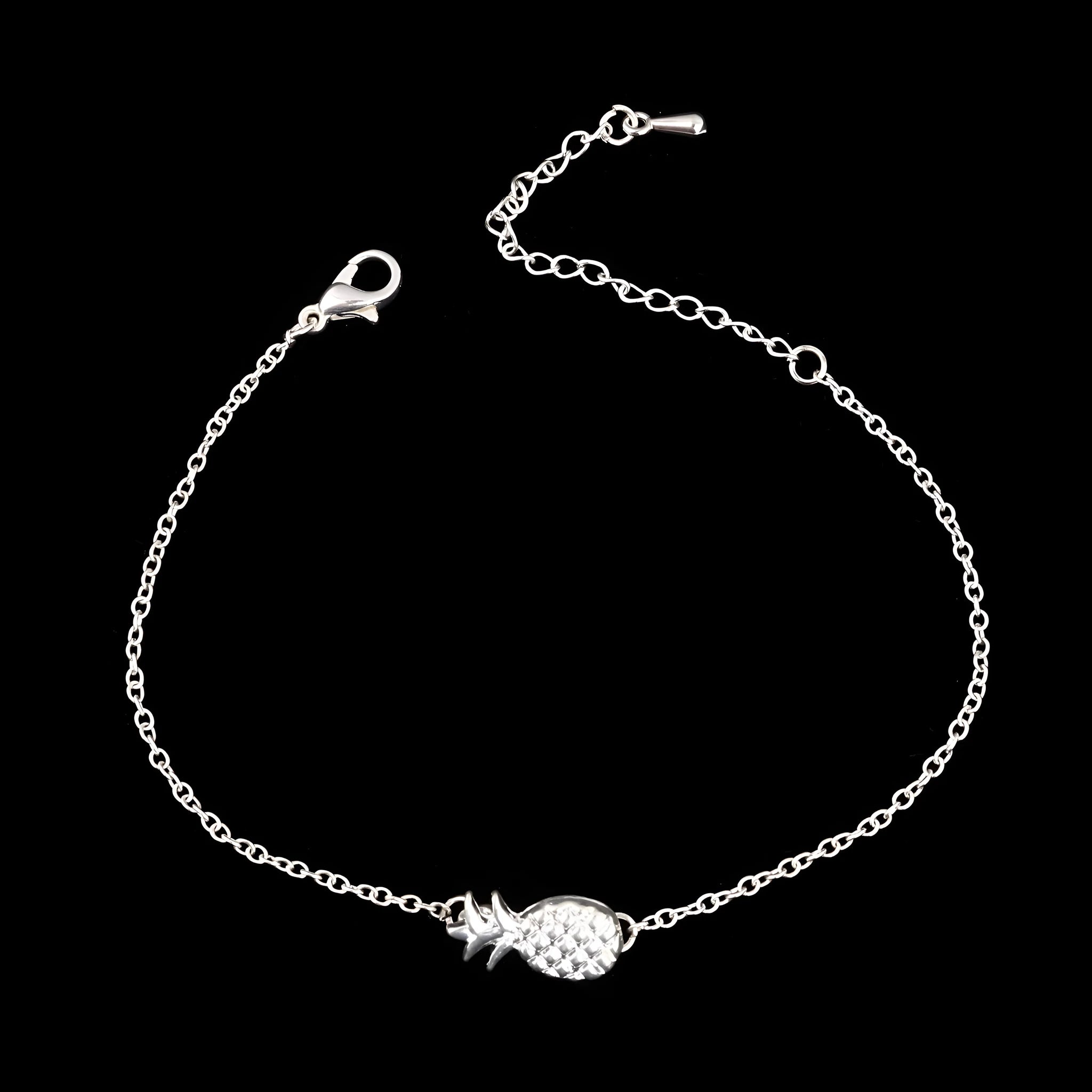 Close-up of a gold-coloured alloy bracelet with a pineapple charm on a simple chain.