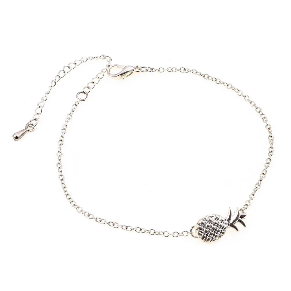 Close-up of a gold-coloured alloy bracelet with a pineapple charm on a simple chain.