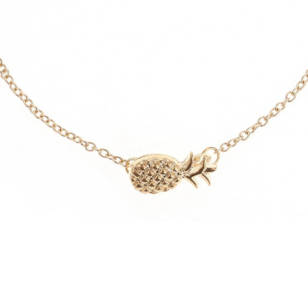 Close-up of a gold-coloured alloy bracelet with a pineapple charm on a simple chain.