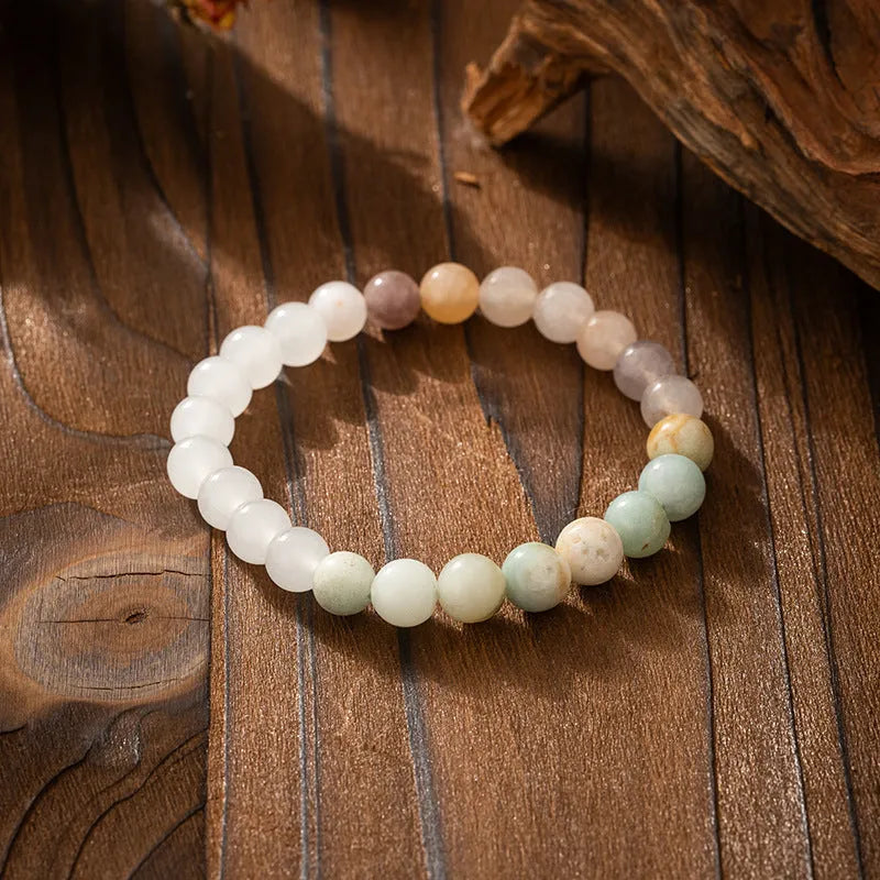 Long natural stone beaded sweater chain necklace and matching bracelet in bohemian style on a grey background.
