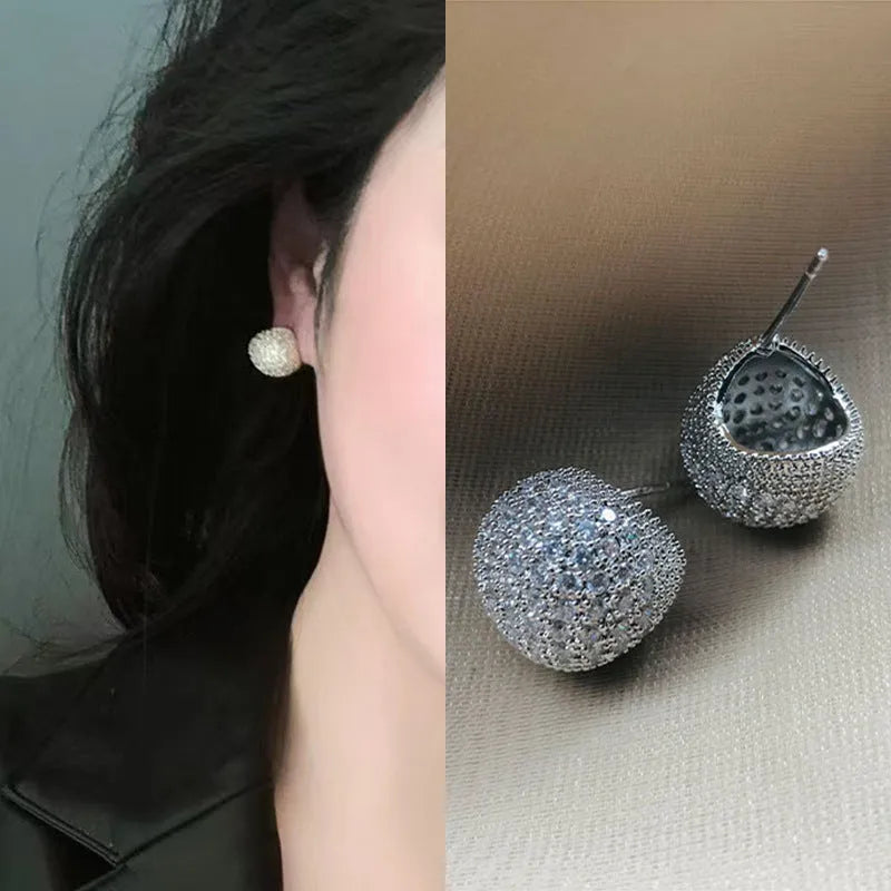 Gold geometric drop earrings with spherical elements and diamond detailing on clip-on backs