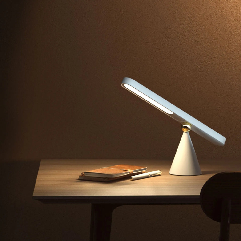 Geometric desk lamp with magnetic base shown attached to metal surface as wall light
