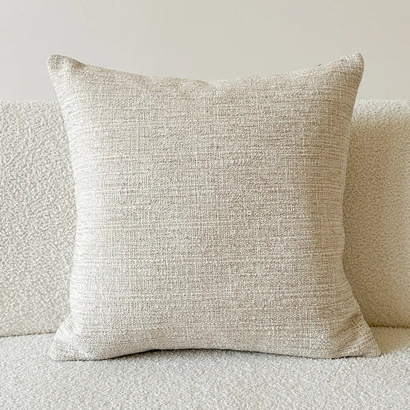 Amber-coloured jacquard pillow cover with paisley and flower pattern, shown in 45x45cm size on a sofa.