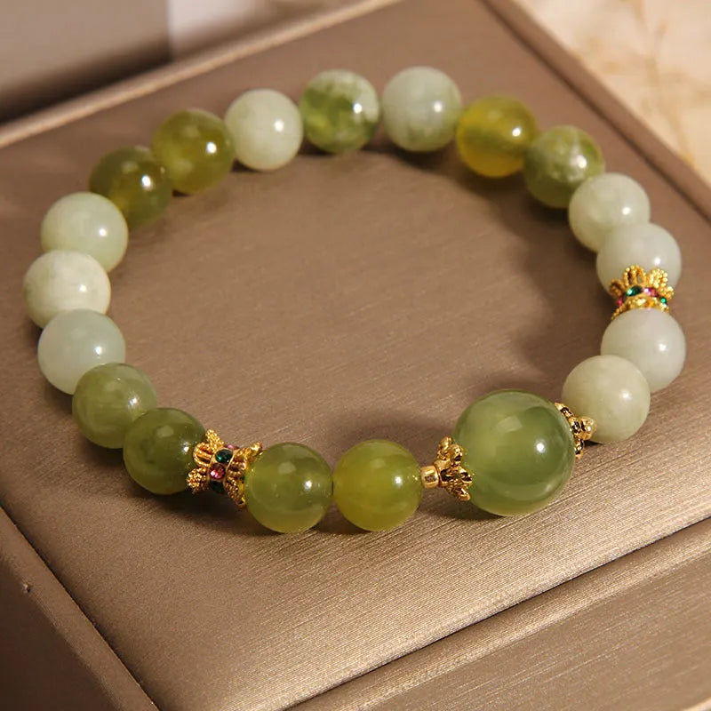 Xiuyan jade green women's bracelet with an original bangle design on a plain background.