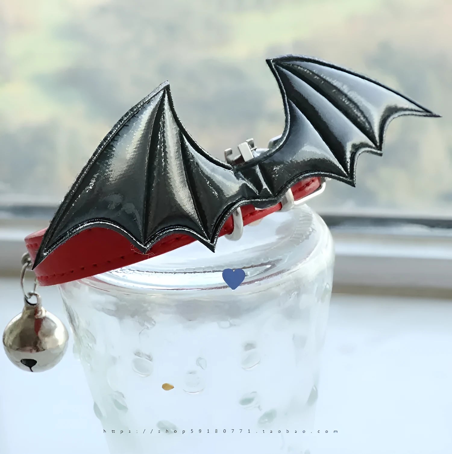 Small leather dog collar with decorative devil wings and bell in patent leather satin