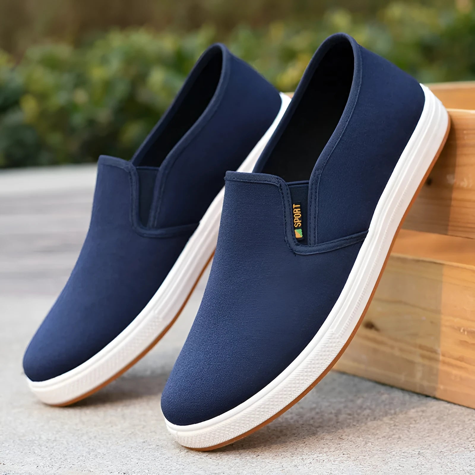 Men's low-top slip-on canvas shoes in black and blue, showing round toe and shallow cut.
