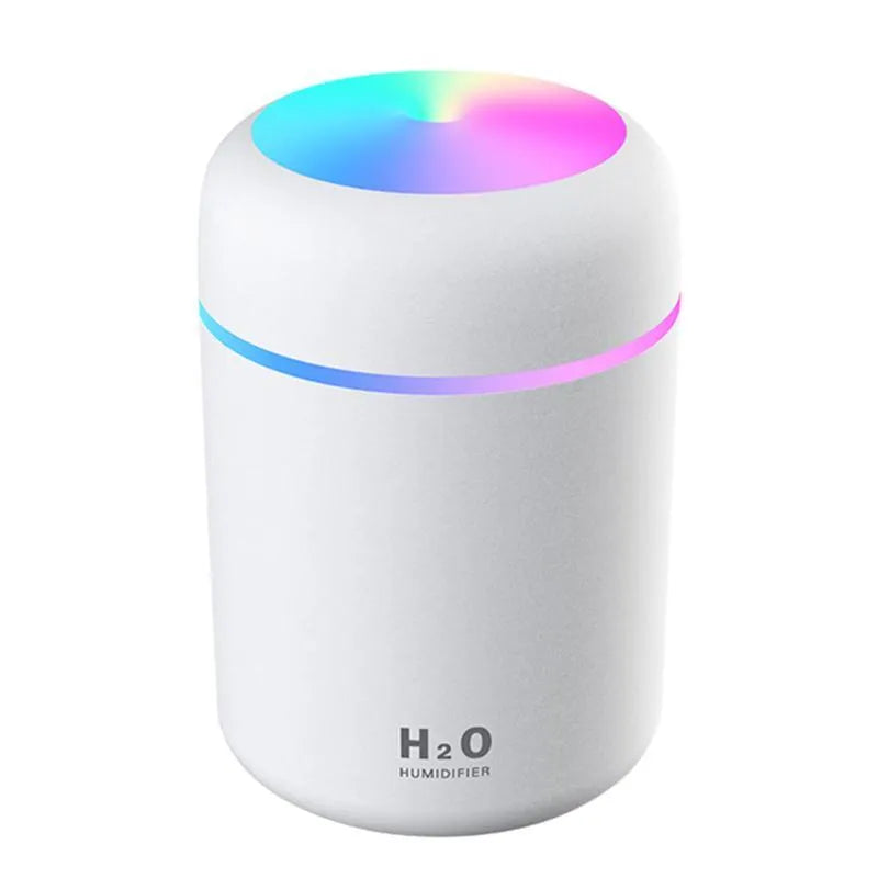Pink USB desktop humidifier with coloured lights and water tank on a wooden desk