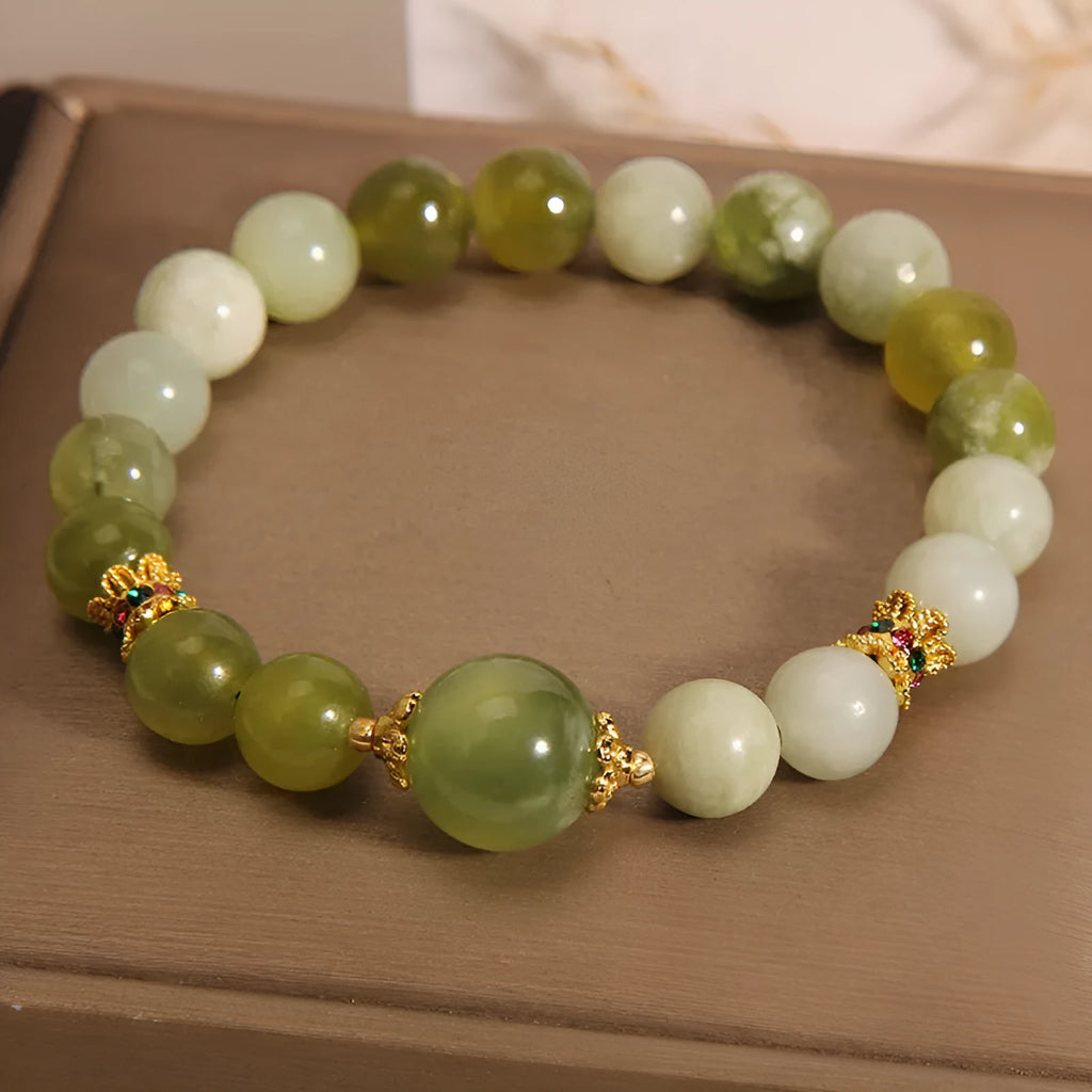 Xiuyan jade green women's bracelet with an original bangle design on a plain background.