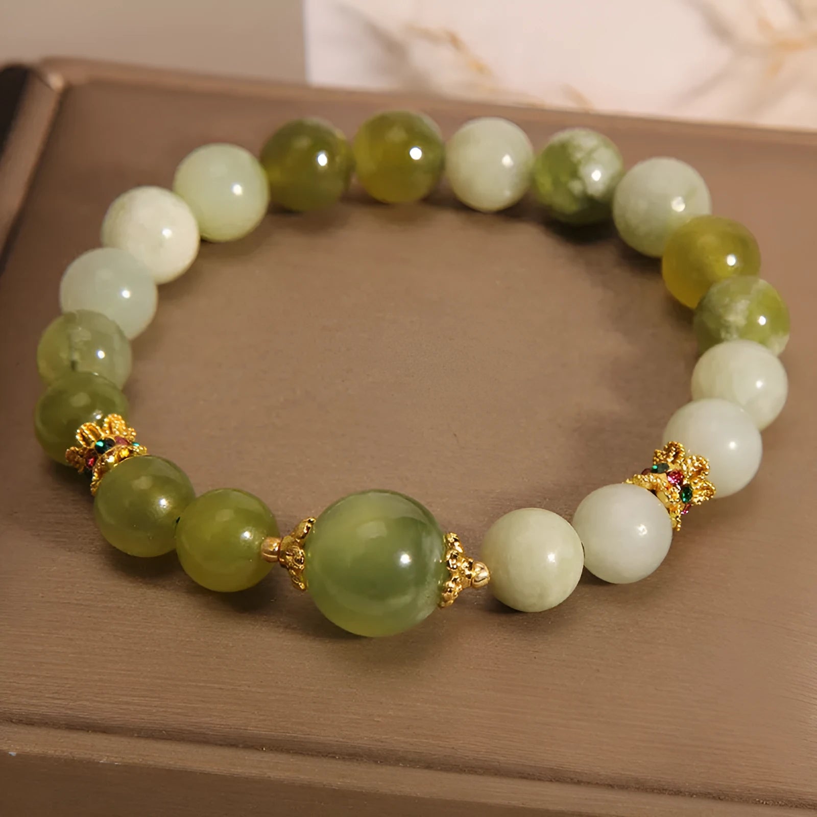 Xiuyan jade green women's bracelet with an original bangle design on a plain background.