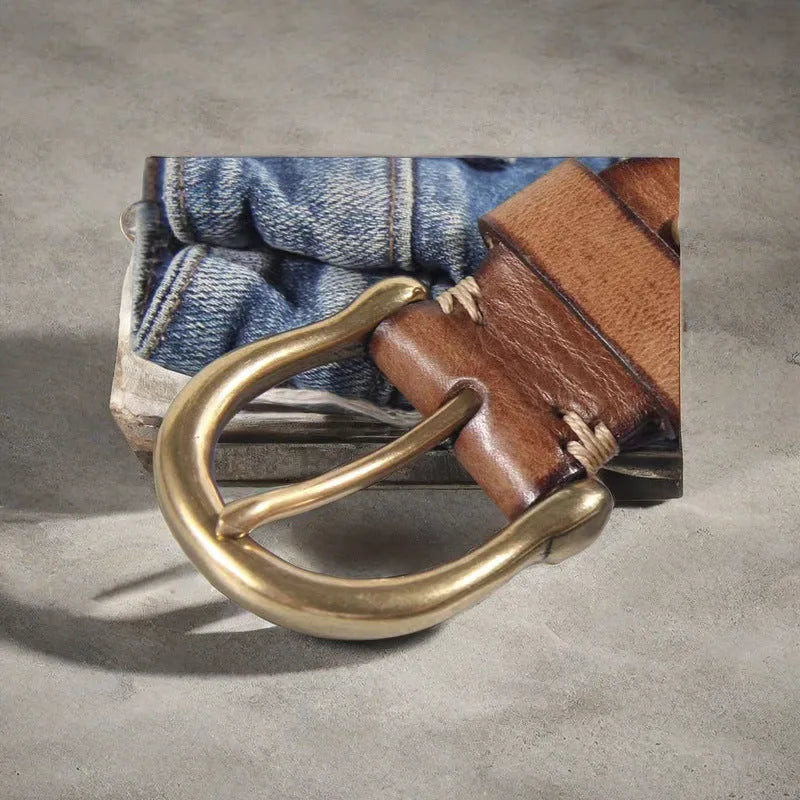 Men's black genuine cowhide leather belt with copper pin buckle on a jeans background.