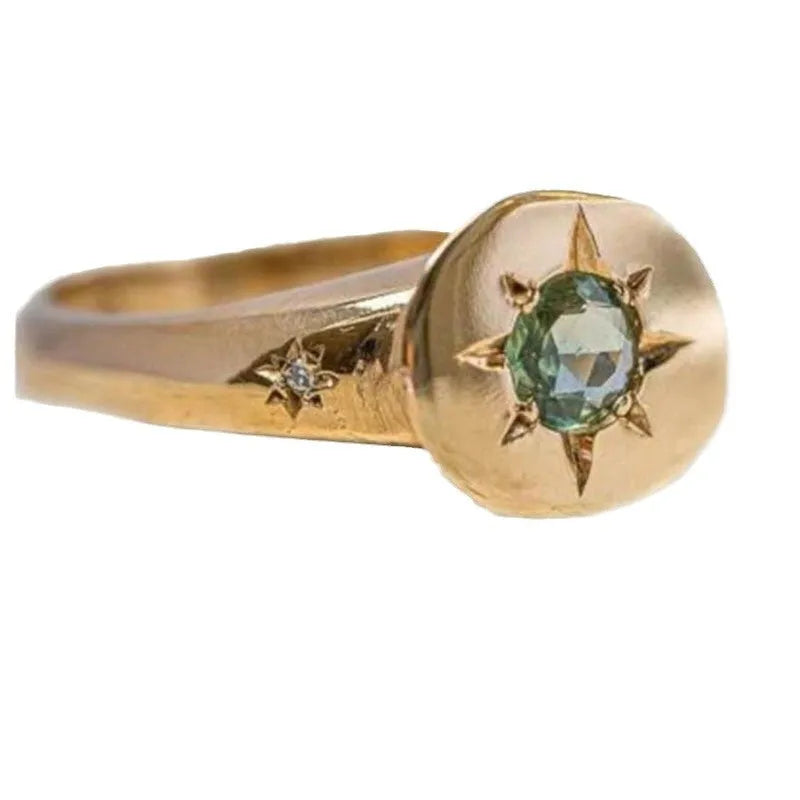 Gold-coloured adjustable ring with a star-shaped asterism zircon stone on a zinc alloy band.