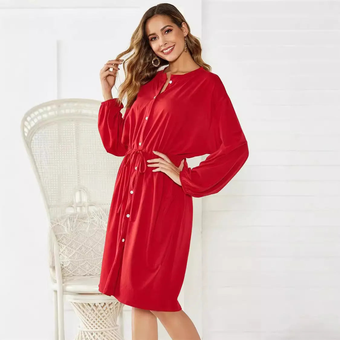 Black A-line midi dress with cinched belt and long sleeves on a mannequin