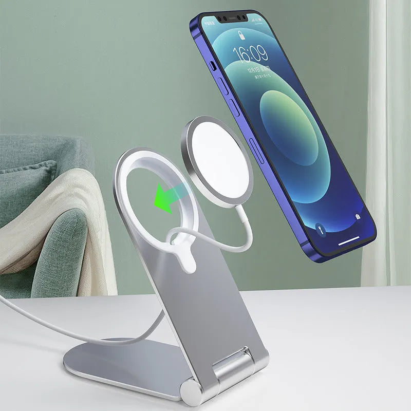 Silver vertical adjustable magnetic phone bracket for iPhone 12 on a table.