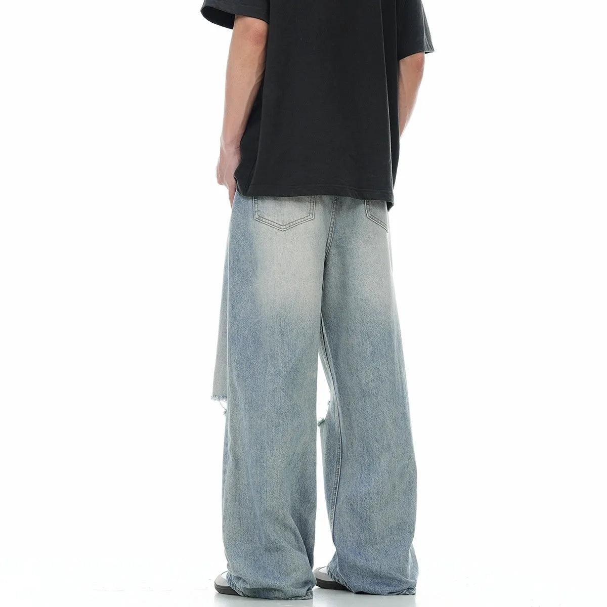 Men's blue straight-leg jeans with ripped detailing on the legs and a zipper fly closure.