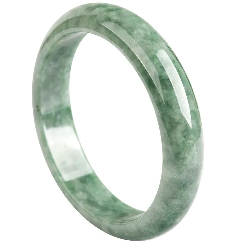 Natural emerald bean green bracelet on wrist, showing simple band and deep green gemstone.