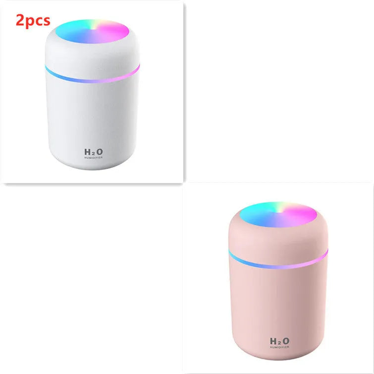 Pink USB desktop humidifier with coloured lights and water tank on a wooden desk