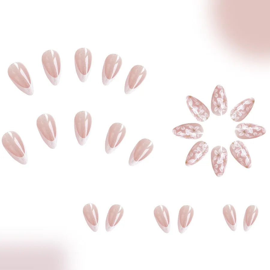 Short almond shaped press-on nails with French style glitter floral designs on a glossy background.