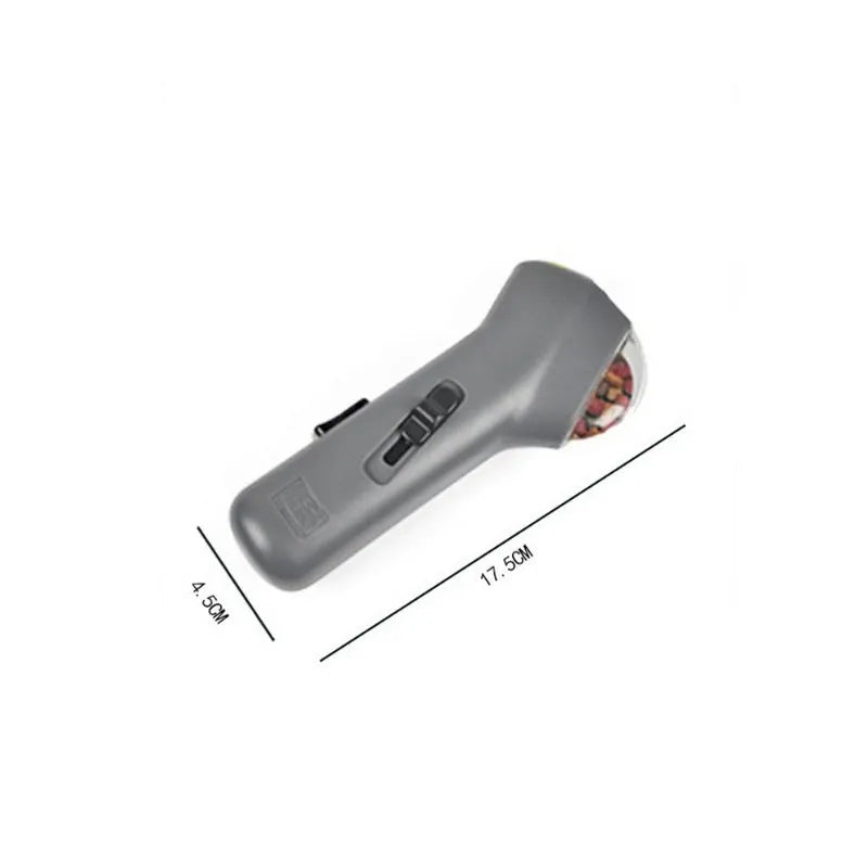 Grey plastic pet snack catapult launcher toy on a plain background.