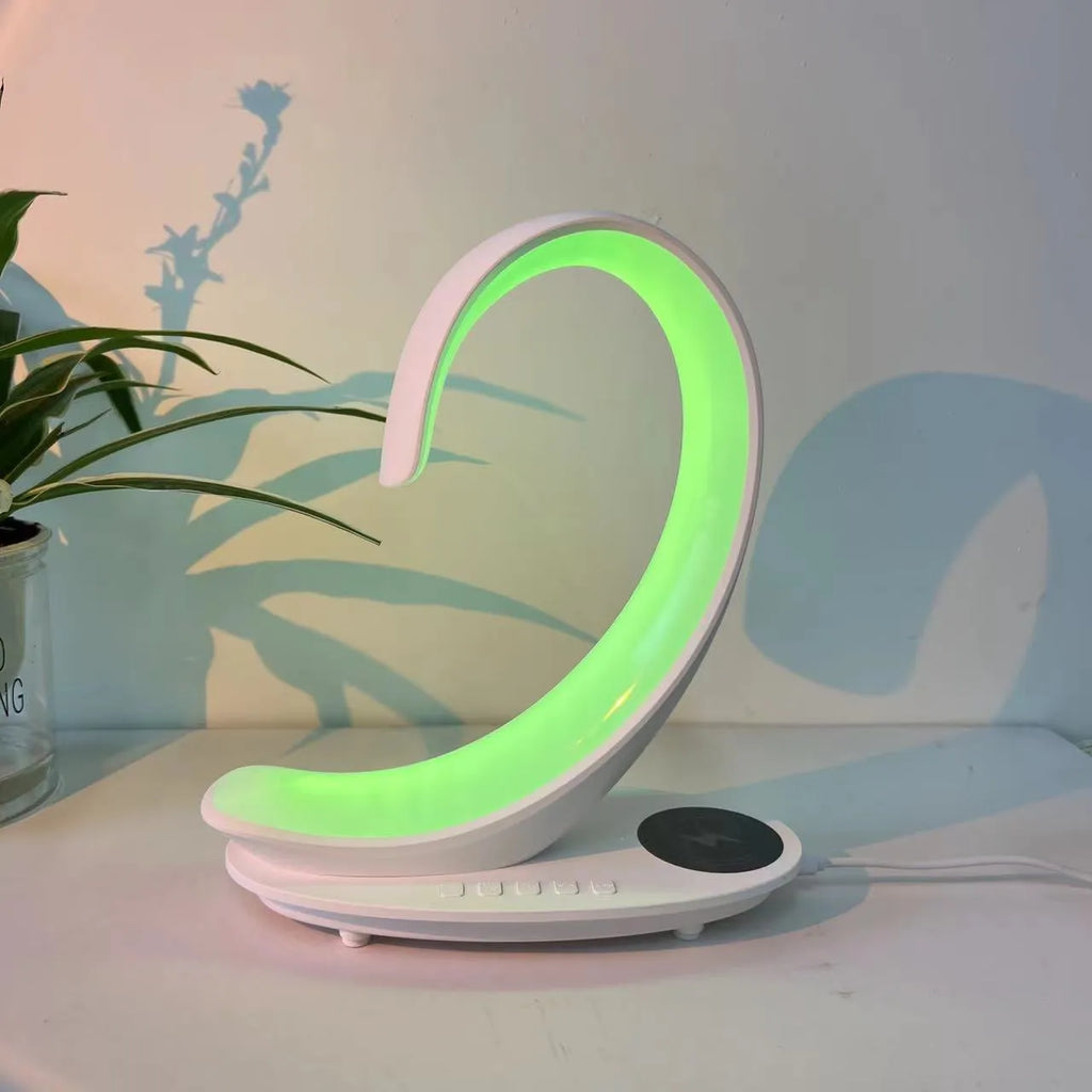 White swan wireless charging Bluetooth speaker with colourful ambient lighting on desktop