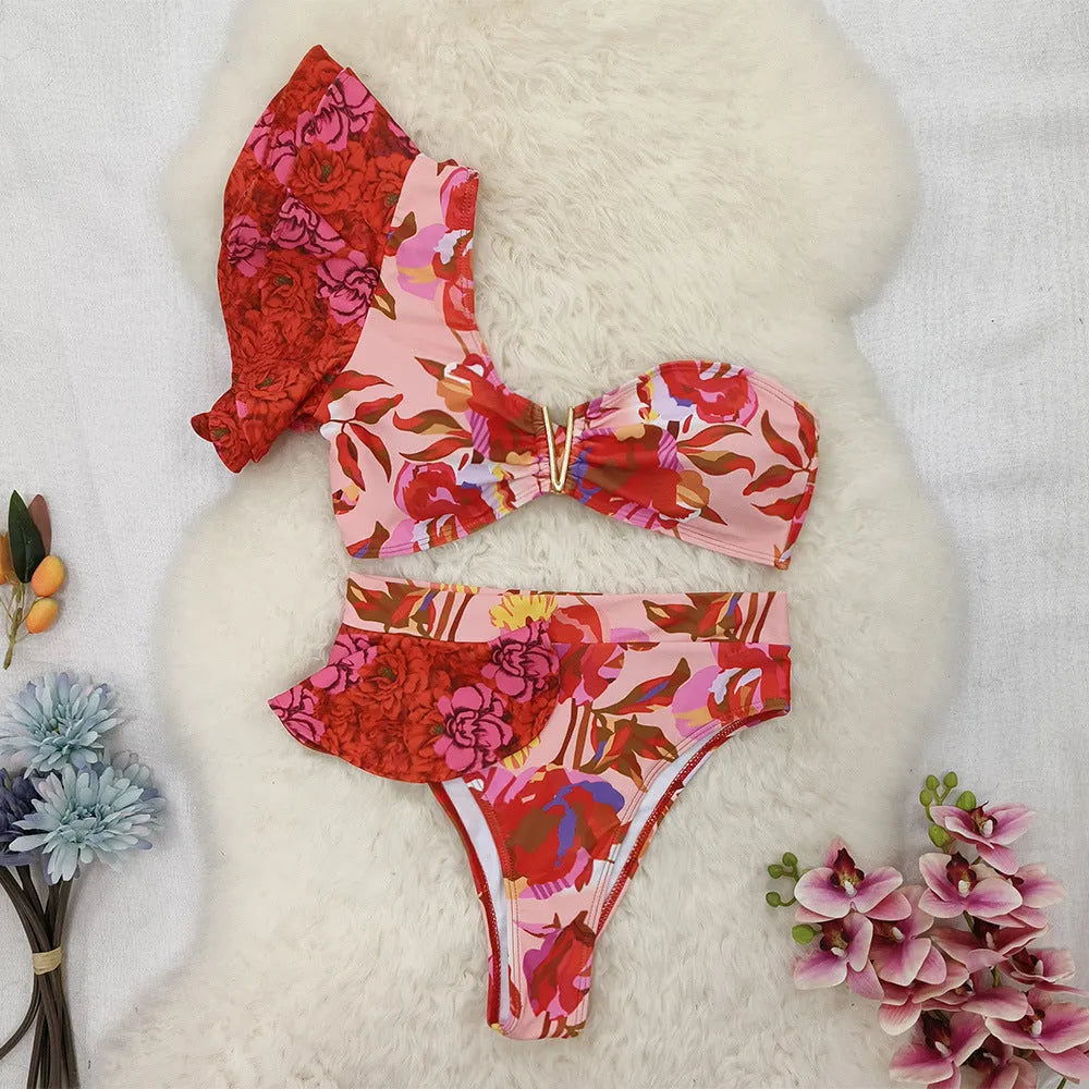 Red floral print on pink women's one-shoulder ruffled bikini with high-waist bottoms.